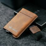 Elevated Extra Slim 1.0 pähklipruun kaarditasku koos eemaldatud elastse paelaga, näidates toote minimalistlikku disaini.
