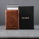 Elevated Slim 2.1 kaarditasku Pearl Copper toonis. Pop-up mehhanismiga alumiiniumkorpus ja stiilne must kinkekarp.