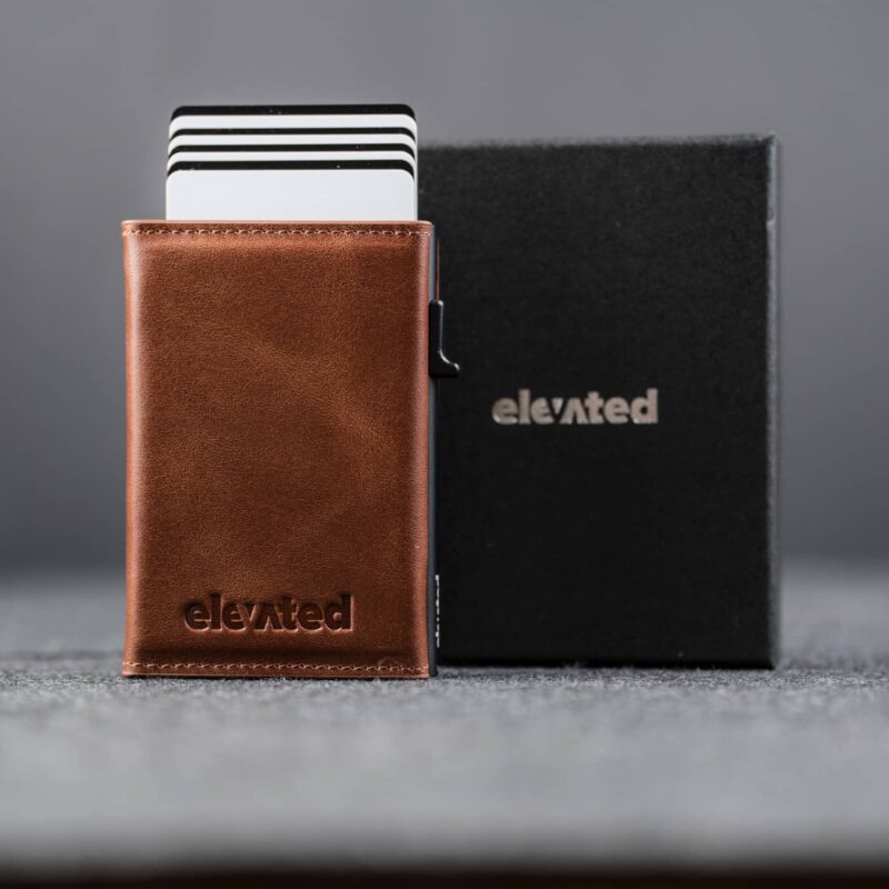 Elevated Slim 2.1 kaarditasku Pearl Copper toonis. Pop-up mehhanismiga alumiiniumkorpus ja stiilne must kinkekarp.