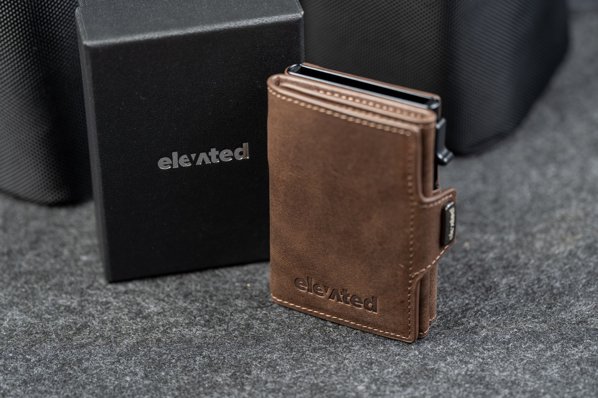Kaarditasku Elevated Snap 1.0 Chocolate Brown, musta kinkekarbi kõrval