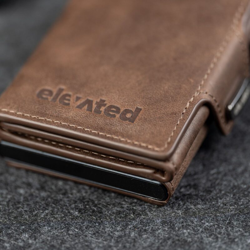 Kaarditasku Elevated Snap 1.0 Chocolate Brown, pressitud Elevated logo lähivaates